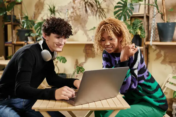 Positive african american woman in braces looking at laptop near curly boyfriend in vegan cafe — Stock Photo