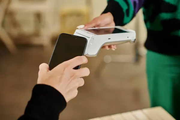Оплата смартфона, обрізаний вид людини, що тримає свій смартфон біля читача карток у веганському кафе — стокове фото