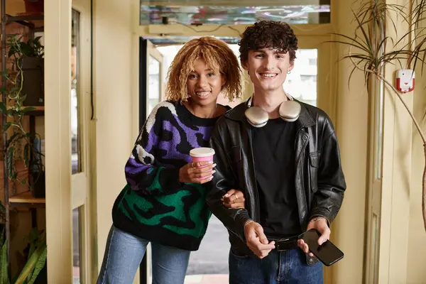 Happy diverse couple in casual attire looking at camera while standing together in vegan cafe — Stock Photo