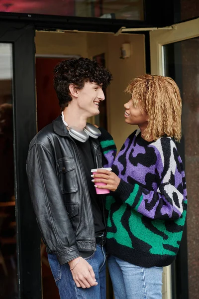 Joyeux et diversifié jeune couple en tenue décontractée bavarder à l'entrée du café végétalien, rendez-vous café — Photo de stock