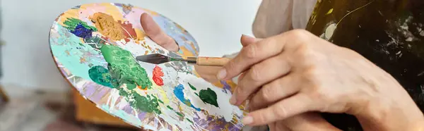 Partial view of mature woman and skilled female mixing paints on palette during master class, banner — Stock Photo