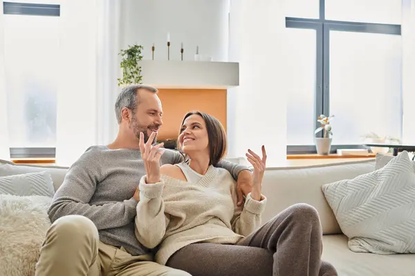 Cheerful wife talking to smiling husband on cozy couch in living room, modern child-free lifestyle — Stock Photo