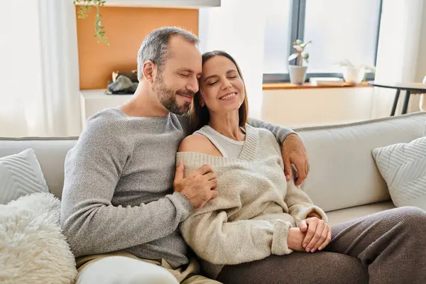 Sonriente pareja sin niños sentado cara a cara con los ojos cerrados en acogedora sala de estar, el amor y el cuidado - foto de stock