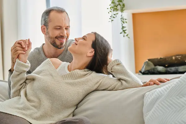 Happy child-free couple holding hands and looking at each other in cozy living room, relax and fun — Stock Photo