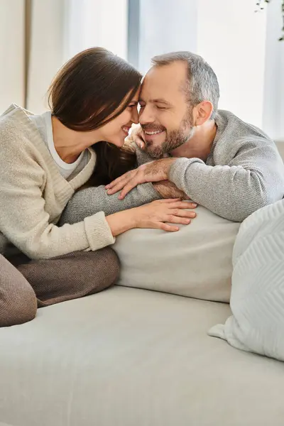 Pareja feliz sin niños sonriendo cara a cara en acogedora sala de estar en casa, unidad y armonía - foto de stock