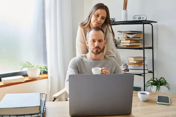 Mujer cariñosa de apoyo marido reflexivo sentado con taza de café en el ordenador portátil en la oficina en casa — Stock Photo