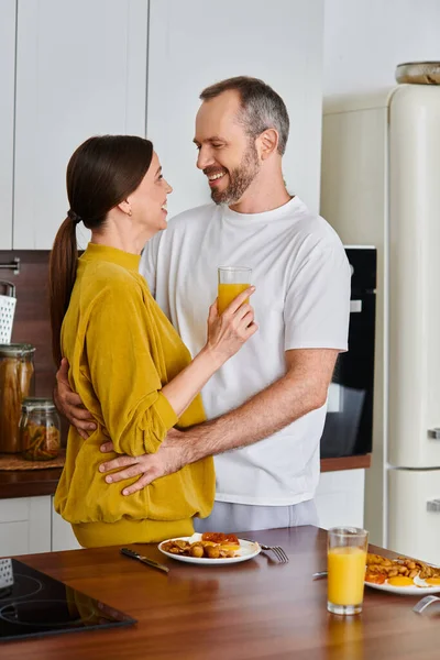 Joyful child-free couple embracing near tasty breakfast in cozy kitchen, love and serenity — Stock Photo
