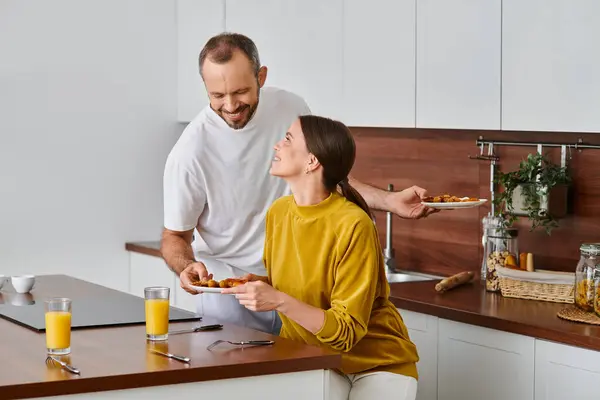 Glücklicher Mann, der leckeres hausgemachtes Frühstück in der Nähe der Frau in der Küche serviert, morgens kinderfreies Paar — Stockfoto