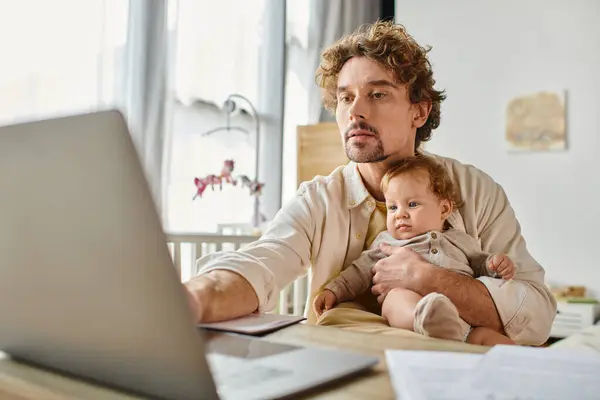Umtriebiger alleinerziehender Vater, der seinen niedlichen kleinen Sohn in der Hand hält, während er von zu Hause aus arbeitet, Work-Life-Balance — Stockfoto