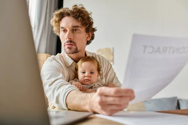 Ocupado pai solteiro segurando filho bebê e contrato em mãos enquanto trabalhava em casa, equilíbrio vida-trabalho — Fotografia de Stock