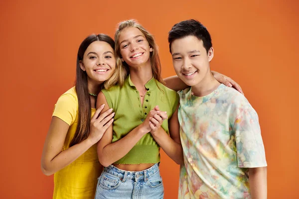 Cheerful pretty multiracial teens in casual bright clothes looking at camera, friendship day — Stock Photo