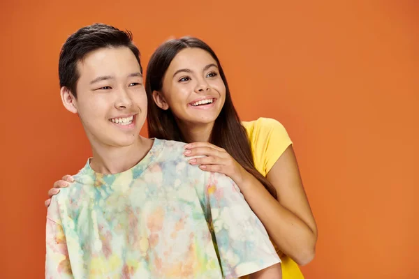 Cheerful diverse teenagers in casual vivid attires posing and looking away, friendship day — Stock Photo
