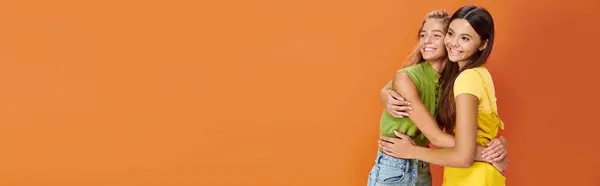 Gioiosa belle ragazze adolescenti in abiti vivaci posa e guardando altrove, giorno dell'amicizia, banner — Foto stock