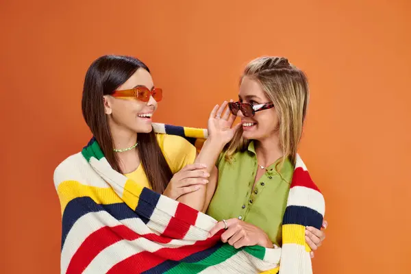 Gioiosa adorabile ragazze adolescenti con occhiali da sole che abbracciano e coprono con coperta, giorno dell'amicizia — Foto stock