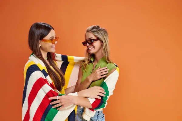 Cheerful pretty adolescent girls with sunglasses hugging and looking at each other, friendship day — Stock Photo