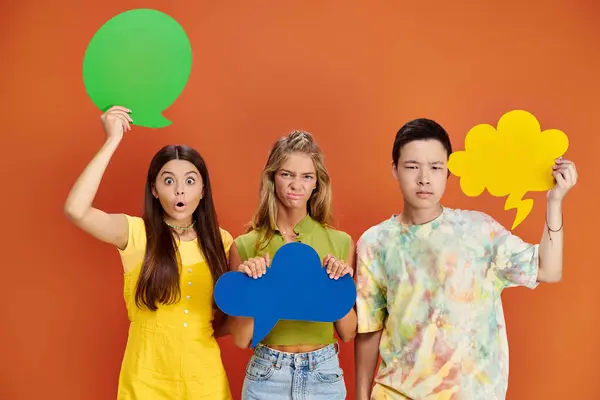 Shocked and upset diverse teenagers holding different thought and speech bubbles, friendship day — Stock Photo