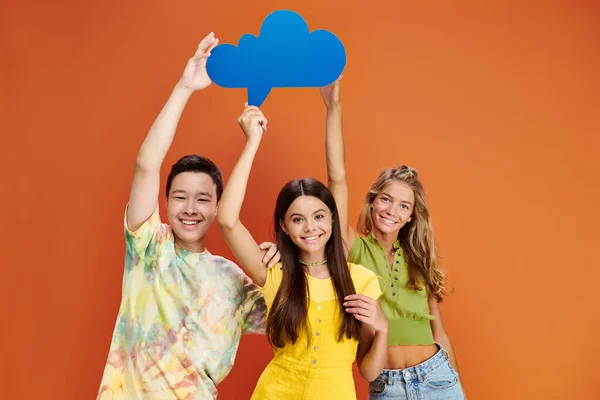 Joyful diverse teenagers posing together with speech and thought bubbles and smiling at camera — Stock Photo