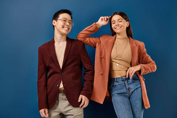 Gioiosi eleganti adolescenti multiculturali in abiti eleganti sorridenti sullo sfondo blu, giorno dell'amicizia — Foto stock