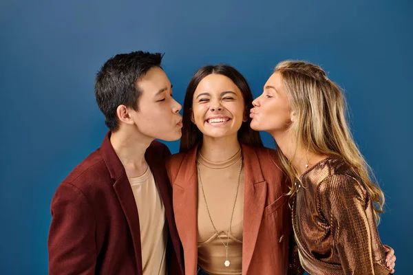 Adorable interracial teenage boy and girl kissing their jolly friend in cheek, friendship day — Stock Photo