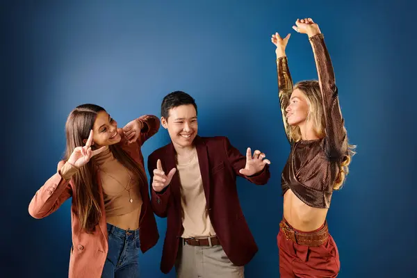 Alegre interracial adolescente amigos na moda roupas se divertindo no fundo azul escuro — Fotografia de Stock