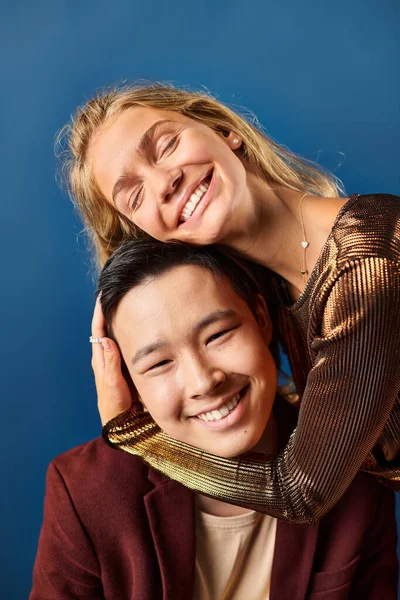 Alegre multicultural adolescentes en elegante vívido trajes abrazando y sonriendo felizmente, día de la amistad - foto de stock