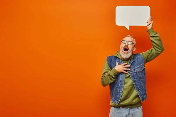 Surprised handsome mature man in stylish green hoodie posing with speech bubble above his head — Stock Photo