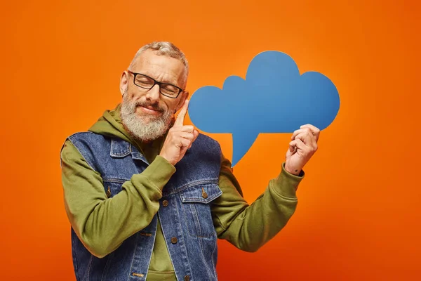Schöne lustige ältere männliche Modell mit Brille und Bart hält Gedankenblase mit geschlossenen Augen — Stockfoto
