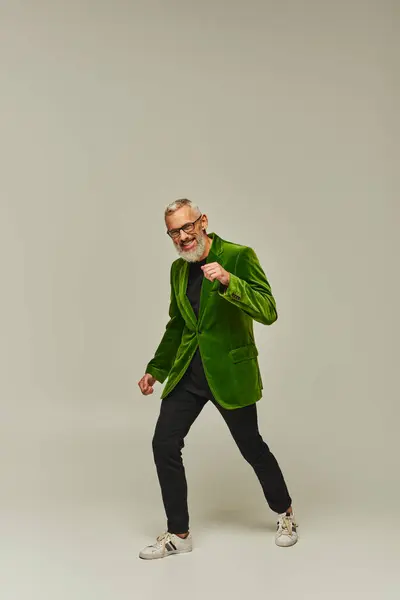 Красивый фанки зрелый мужчина в зеленом ярком блейзере с аксессуарами счастливо улыбаясь в камеру — стоковое фото