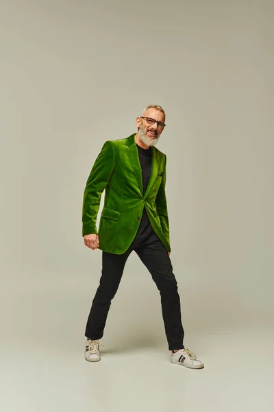 Cool gai mature mâle modèle en vert vif blazer avec barbe grise souriant sincèrement à la caméra — Photo de stock