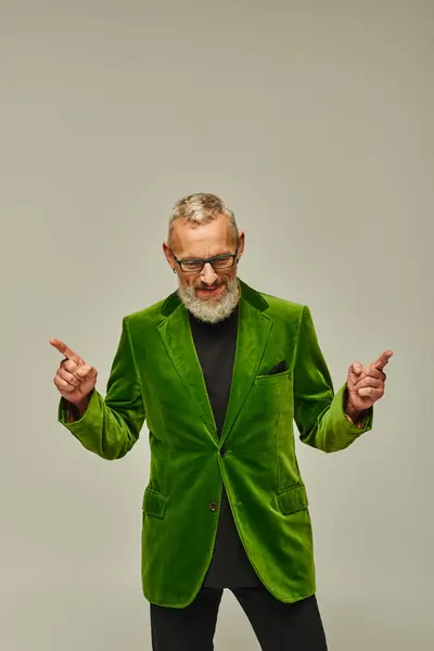 Gut aussehende flippige lustige ältere männliche Modell mit grauem Bart und Brille posiert und schaut nach unten — Stockfoto