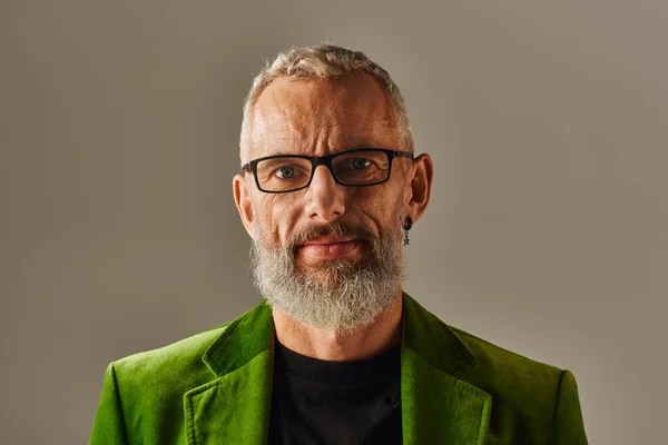 Joyeux attrayant homme mûr dans veston vert vibrant avec des lunettes et de la barbe en regardant la caméra — Photo de stock