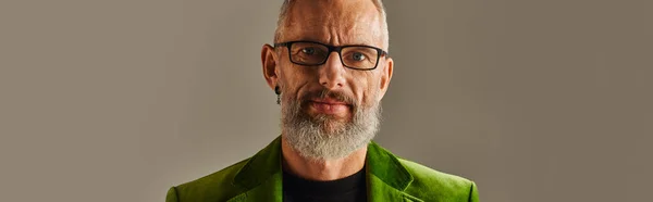 Gioioso bello uomo maturo in giacca verde con occhiali e barba guardando la macchina fotografica, banner — Foto stock