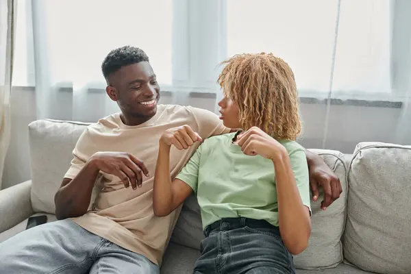 Schwarzes Paar kommuniziert zu Hause mit Gebärdensprache, Frau in Zahnspange schaut Mann an — Stockfoto