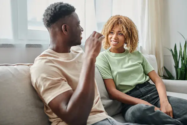 Sign language, happy african american woman in braces looking at boyfriend showing hand gesture — Stock Photo