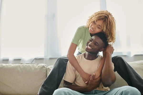 Freudige afrikanisch-amerikanische Frau umarmt Freund im Wohnzimmer, schwarzes Paar, das Zeit hat — Stockfoto