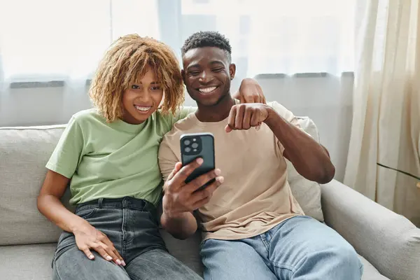 Счастливая африканская пара американских видео чата на смартфоне, показывая язык жестов — стоковое фото