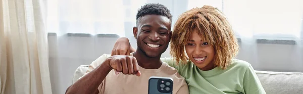 Feliz casal afro-americano vídeo conversando em um smartphone enquanto mostra a língua de sinais, banner — Fotografia de Stock
