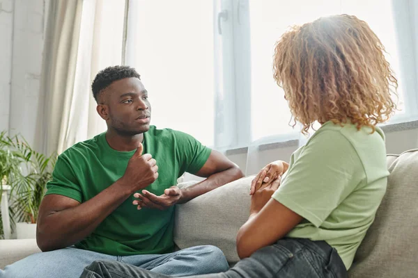 African american man showing help gesture while communicating with sign language near girlfriend — Stock Photo