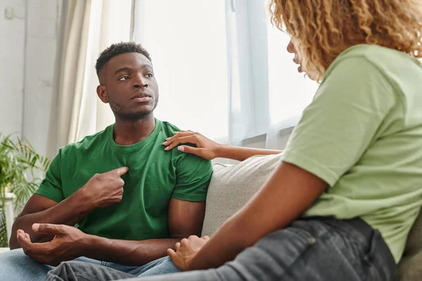 Black man pointing at himself while communicating with girlfriend and using sign language — Stock Photo