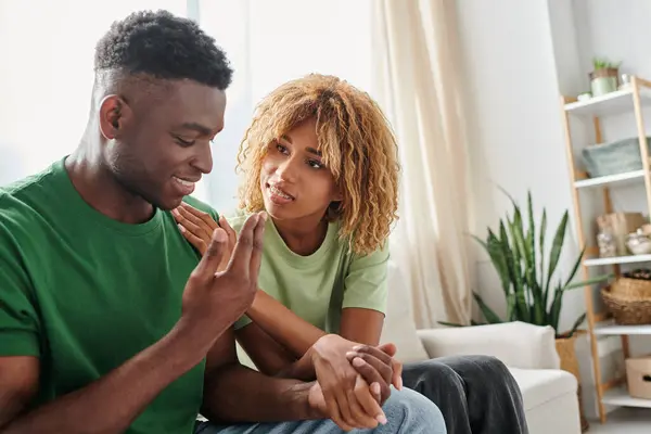 Joven afroamericano pareja cogido de la mano mientras sentado juntos en sofá, apoyo emocional - foto de stock
