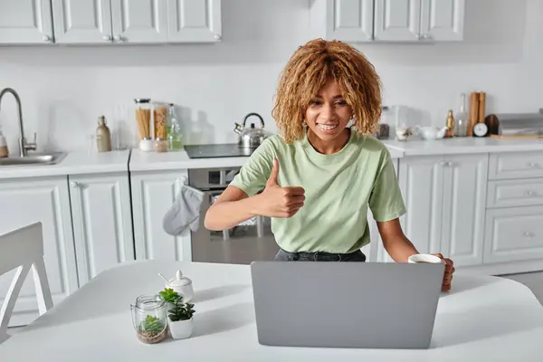 Heureuse femme afro-américaine montrant pouce vers le haut lors d'un appel vidéo sur ordinateur portable, comme geste — Photo de stock