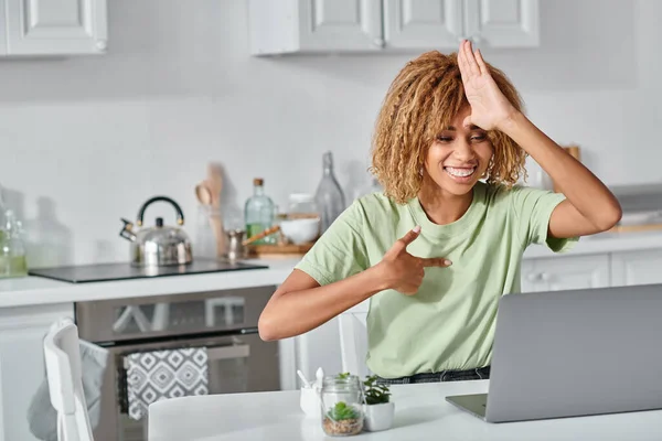 Весела афроамериканська жінка використовує мову жестів під час відеодзвінка на ноутбуці, спілкування — стокове фото