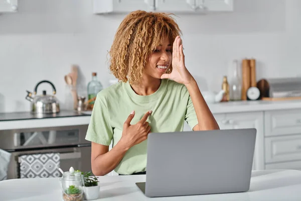 Mujer afroamericana positiva usando lenguaje de señas durante la videollamada en el ordenador portátil, comunicación — Stock Photo