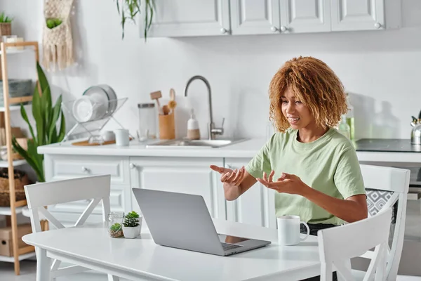Cheerful young african american woman using sign language during video call on laptop, connection — Stock Photo