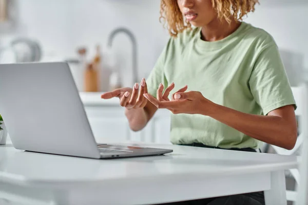 Обрезанная африканская американка в брекетах с использованием языка жестов во время видео-чата на ноутбуке, подключение — стоковое фото