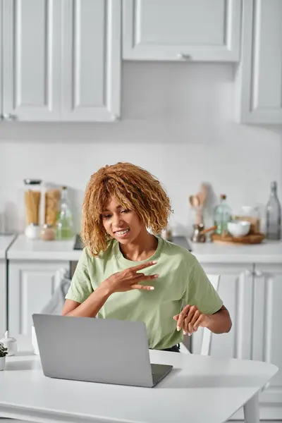 Happy african american girl in braces using sign language during video call on laptop, conversation — Stock Photo