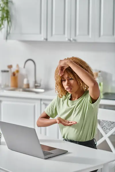 Focused african american girl in braces using sign language during video call on laptop, gesture — Stock Photo