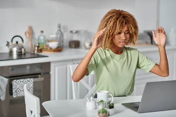 Curly african american woman in braces using sign language during video call on laptop, gesture — Stock Photo