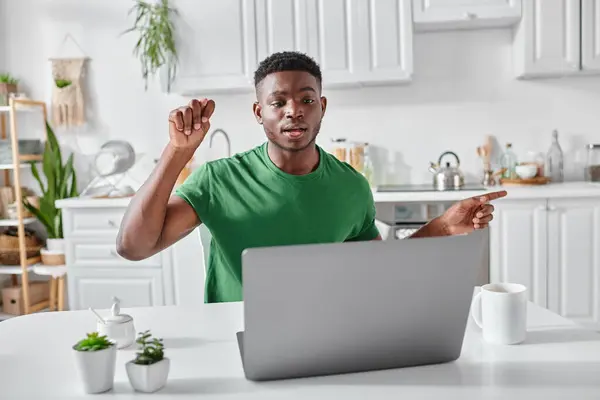 Freelancer afro-americano surdo usando linguagem gestual durante videochamada no laptop em casa, explique — Fotografia de Stock