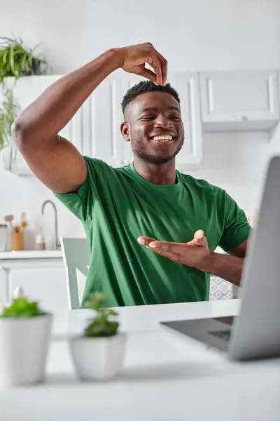 Alegre sordo afroamericano freelancer utilizando lenguaje de señas durante la reunión en línea en el ordenador portátil - foto de stock